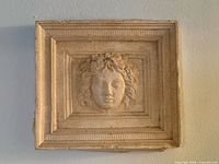 Front view of square plaster plaque showing complete relief face and borders