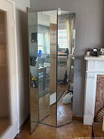 Room divider folded partly open showing mirrored fronts