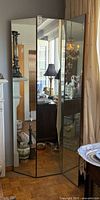 Mirrored front of three-panel divider reflecting room
