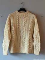 Front view of cream cable knit wool sweater