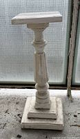 Full view of white wooden pedestal stand