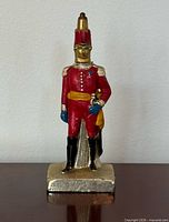 full front view of painted metal Royal Guard pen stand with pen inserted