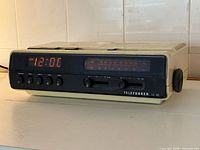 Front and left perspective of Telefunken EC-100 showing LED clock and controls