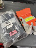 Two pairs of new work gloves, one sealed winter pair and one hi-vis leather palm pair