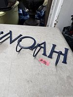 blue cast iron NOAH letter hooks on tabletop