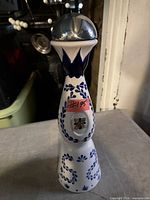 Full view of ceramic bottle with stopper in place showing blue patterns and height proportions