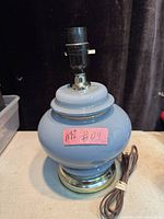 Front view of blue ceramic lamp on brass-tone base showing socket and cord