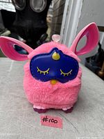 Front view of pink Furby with blue sleep mask accessory in place