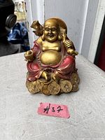 Front view Laughing Buddha figurine on coins