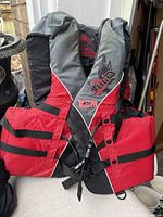 Front view of red and grey Fluid life jacket showing straps and buckles