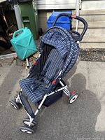 Front view of blue plaid folding umbrella stroller