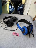Sony black wired on-ear headphones and Skullcandy blue wired over-ear headphones on tabletop