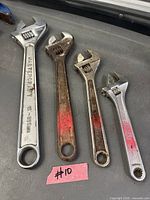 Four adjustable wrenches in graduated sizes with visible wear