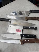 Six knives laid out showing variety of handles and blade lengths
