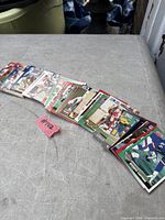 Spread of approximately 30 assorted NFL football cards on table