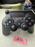 Front view showing buttons, analog sticks missing rubber, PlayStation logo, wear