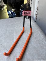 Front view of Tornado storage hook with mounting plate and orange arms