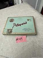 Top view of vintage Player's Navy Cut Cigarettes tin showing logo, tax stamp, wear, rust