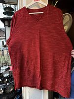 Front view of red heather Under Armour V-neck fitted T-shirt on hanger