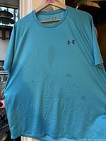 Front view of light blue Under Armour Tech Tee showing stains and logo