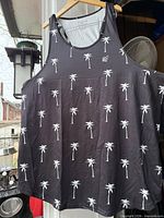 Front view of black tank top with white palm tree pattern