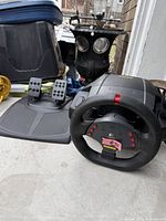 Logitech MOMO Racing Force steering wheel and pedal set on concrete floor