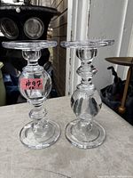 Pair of clear glass reversible candle holders on table