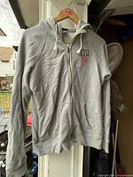 Front view of grey Nike zip hoodie on hanger