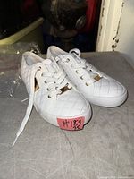 Top view of both white quilted GBG sneakers with laces and gold logo hardware