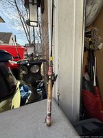 Full view of rod with reel attached leaning against wall