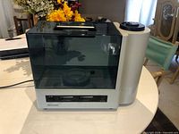 Front view showing cream base, control panel, translucent tank