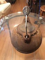 Top view showing cast iron kettle with spring handle and damaged lid