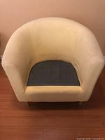 Front view of cream barrel armchair without seat cushion showing interior base