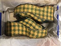 Pair of woven straw wedge mule sandals inside box