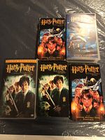 Front view of five Harry Potter VHS and DVD cases showing titles and language variants