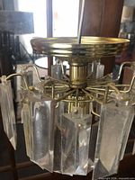 side view showing brass canopy, cord and hanging acrylic prisms