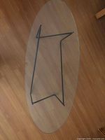 Top view of oval glass table showing overall shape and metal base
