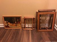 Overall view showing one framed art print on left, three medium frames centre, two large frames right