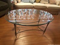 Front view of oval glass coffee table showing top and frame