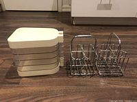 Plastic caddy and two chrome utensil holders side by side