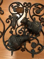 Close view of one panel showing jug motifs, scrollwork, rust patina