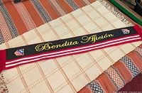 Full view of Atlético de Madrid scarf displaying Bendita Afición text and club crests