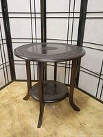 Full view of assembled round carved side table with lower shelf
