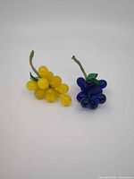 Yellow and blue glass grape clusters side by side