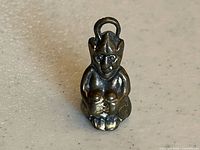 Front view of brass Lincoln Imp pendant showing figure details and patina