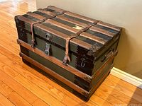 Closed trunk showing exterior materials, leather straps, lock and slats