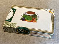 Closed Cuaba cigar box showing top artwork, tax seal, and branding