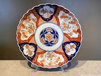 Full view of Imari plate on stand showing entire design and scalloped rim