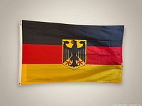 Full view of German flag showing tricolor and coat of arms
