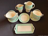 Overall set layout showing pitchers, cups, saucers, tray, dessert plate